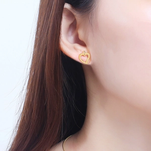 Elegante goldene Herz-Ohrstecker am Modell für einen minimalistischen Schmuck-Look