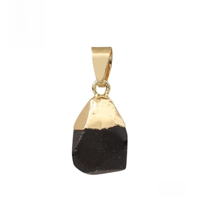 Detailed close-up of natural black stone pendant with gold-plated metal clasp on white background