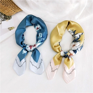 Peacock blue and yellow floral silk scarves styled on a white fabric background