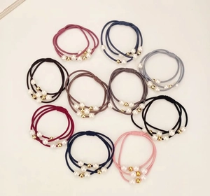 Detail of 10-piece pearl hair ties set featuring elastic three-strand ropes and gold beads