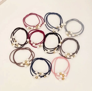 Detail view of 10-piece elastic hair tie set with faux pearls and metallic gold beads