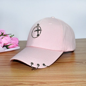 Pink baseball cap featuring silver ring decorations and a small plane pendant charm