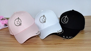 Detailed view of pink, white, and black baseball caps with stylish metal rings and stars