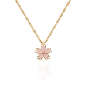 Macro detail of a cherry blossom pendant with pink petals and a crystal core on a gold chain