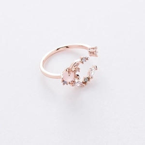 Detail of rose gold open ring featuring a crescent moon with pink zircon stones