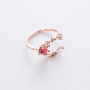 Detail of rose gold moon star ring with red gemstone and cubic zirconia accents