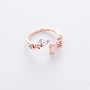 Close-up of rose gold flower ring with pink heart stone and zircon petals