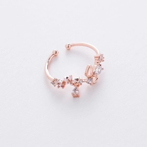 Detail of rose gold flower ring featuring micro-set cubic zirconia and a small pendant