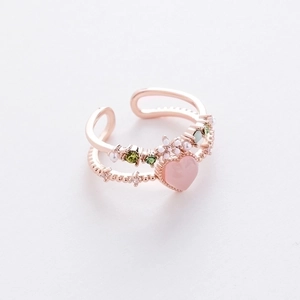 Detail of rose gold double-layer ring with pink heart stone and floral accents