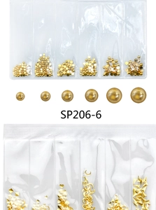 Macro view of golden metal nail art studs and pearls in a six-grid package