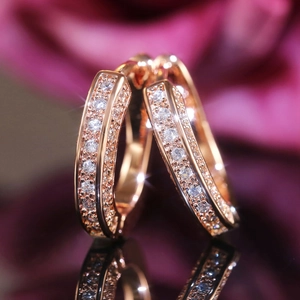 Macro view of rose gold U-shaped earrings with double rows of sparkling crystals