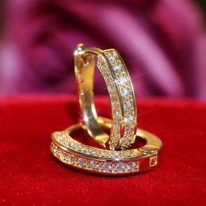 Macro shot of gold-plated U-shaped hoop earrings with pave-set shimmering cubic zirconia