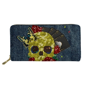 Detail of gothic skull wallet with butterfly, rose and poker card patterns on denim texture