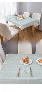 Detail of light green checkered waterproof PEVA tablecloth on rectangular wood table