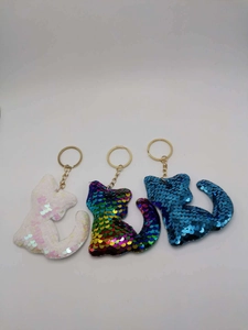 Three sequined cat-shaped keychains in white, rainbow, and blue with golden metal rings
