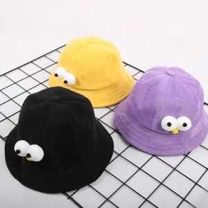Detail view of colorful kids sun hats with 3D cartoon eyes on a black mesh stand