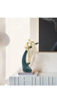 Modern abstract duo-bird ornament featuring a glossy gold finish and emerald green base