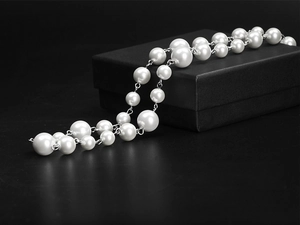 Detail view of hip-hop pearl necklace with metal chain on elegant black gift box