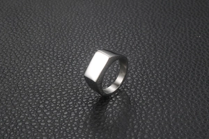 Close-up of a silver rectangular signet ring on black leather with metallic highlights