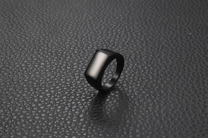 Macro shot of rectangular matte black stainless steel signet ring on black leather