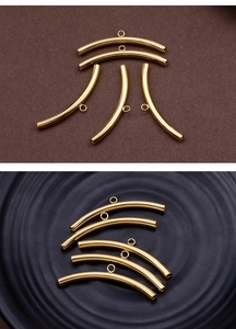 Macro shot of curved golden metal tube beads with small rings for DIY jewelry making