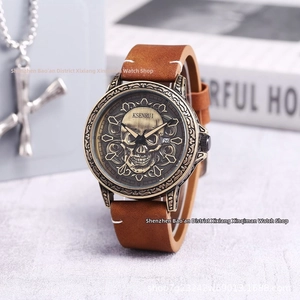 Detail of vintage men's quartz watch with bronze skull relief dial and leather strap