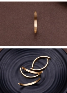 Detailed view of matte gold curved metal connector bars for DIY jewelry making