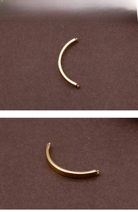 Close-up of polished gold-plated stainless steel curved bar connectors for DIY jewelry