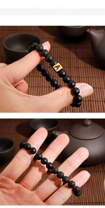 Macro shot of black lava rock beads and golden letter A charm on a beaded bracelet