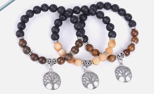 Detailed view of Tree of Life charms on volcanic stone and ebony wood beaded bracelets