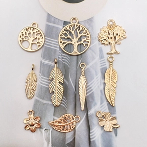 Macro shot of assorted gold metal charms including life tree and feather for DIY jewelry