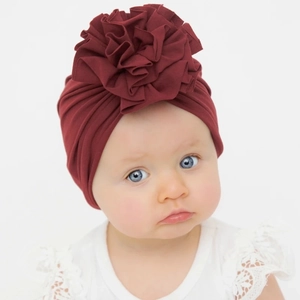 Baby turban hat with large pleated flower design made of soft deep red knitted cotton