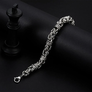 Polished titanium steel chain bracelet with intricate links on black display stand