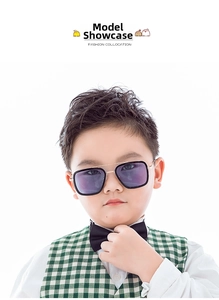 Kids fashion sunglasses with golden metal frames and dark lenses on a stylish model