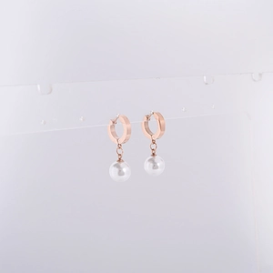Gros plan de créoles en or rose 18 carats avec perles élégantes sur support transparent