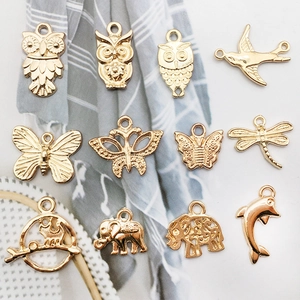 Macro view of assorted gold metal animal charms including owls and butterflies