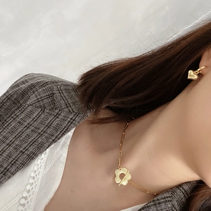 Detail of 925 silver flower toggle necklace and heart earrings on a stylish model