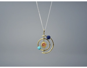 Detailed shot of solar system necklace with sun charm and planetary beads on silver chain