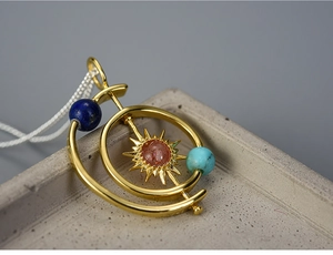 Macro detail of solar system necklace with natural stone and rotating gold sun pendant
