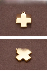 Makro-Detail eines polierten Goldkreuzes mit oberer Lochung für DIY-Schmuckherstellung