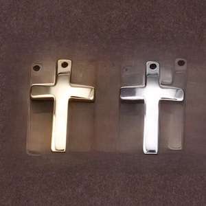 Minimalist gold and silver cross pendants with polished metallic finish on dark felt