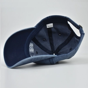 Detail of navy washed cotton baseball cap showing interior sweatband and metal buckle
