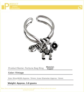 Macro shot of retro silver ring featuring a money bag, horse, and flower charm details