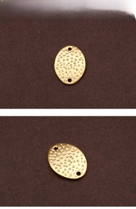 Detailed view of golden oval hammered metal jewelry connectors for DIY bracelets