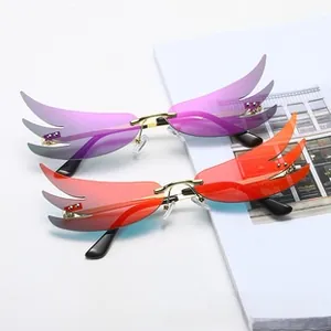 Close-up of rimless flame-shaped sunglasses with gradient lenses and gold metal bridge