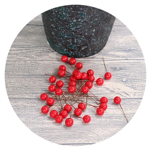 Artificial red holly berries decoration on grey wood background with ceramic vase