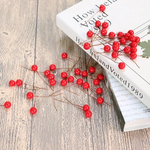 Vibrant artificial red berries on wooden desk with book for Christmas home decor