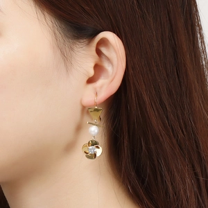 Boucles d'oreilles baroques dorées avec perle géométrique et trèfle sur le mannequin