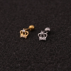 Macro view of gold and silver crown stud earrings with clear zircon stones