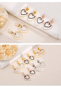 Detail of double heart earrings with bow hooks in gold, silver, and black finishes